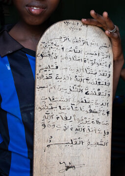 Boy with a wood board for writing koran in a coranic school, Tonkpi Region, Man, Ivory Coast