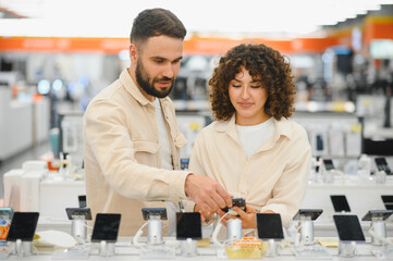 Couple choosing smartphone in electronics store