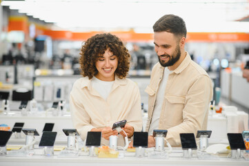 Couple choosing smartphone in electronics store