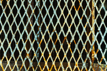 Close-up of an old locomotive and old carriages on a decommissioned railway, the paint cracked, peeled and rusted.