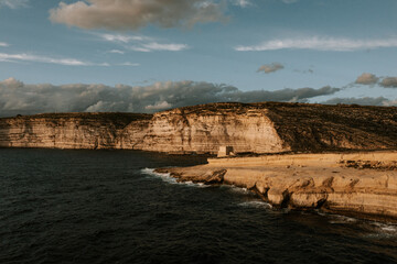 Steilküsten von Malta und Gozo bei Sonnenuntergang – Luftaufnahme mit Turm auf Gozo Urlaub