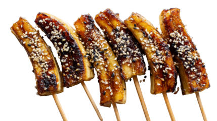 Grilled caramelized bananas on skewers with sesame seeds, white isolate background.