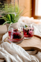 Homemade fruit lemonade with blackcurrants, orange slices and mint leaves. Bright and refreshing, perfect for a summer gathering or picnic