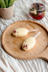 Minimalist creamy dessert coated with silky white chocolate and sprinkled with berry flakes. Gourmet-style, sugar-conscious treat.