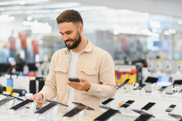 Customer comparing smartphones and reading reviews in electronics store