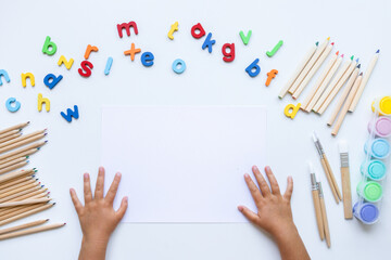 Child creative desk with alphabet letters, colored pencils, paints, and brushes