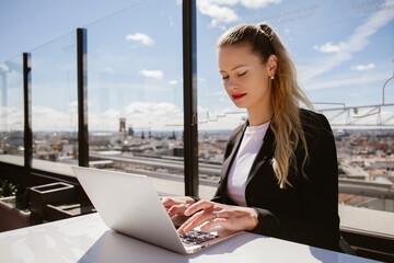 Businesswoman working on laptop with madrid skyline view