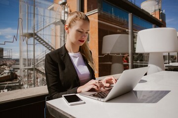Businesswoman working on laptop in madrid rooftop terrace