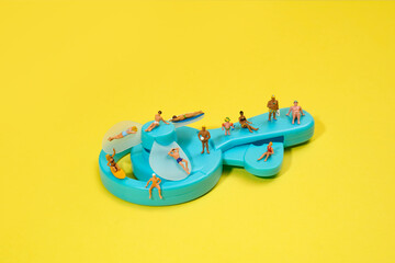 miniature bathers on a blue hand-powered fan