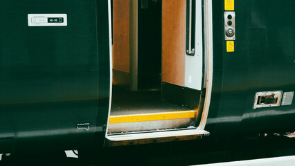 Green colored train engine on rails in city landscape, modern transport scene