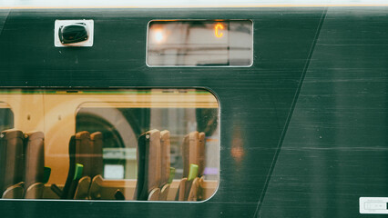 Green colored train engine on rails in city landscape, modern transport scene