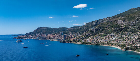 Obraz premium panoramic aerial landscape view of Mediterranean coastline of Monaco - officially the Principality of Monaco - located on French Riviera with skyline and skyscraper as well as yachts and cruise ships
