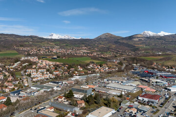 High angle view of a residential town, industrial zone and snowcapped mountains in southeastern...