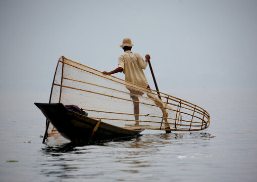 Man rowing a fishing boat, Inle lake, Myanmar