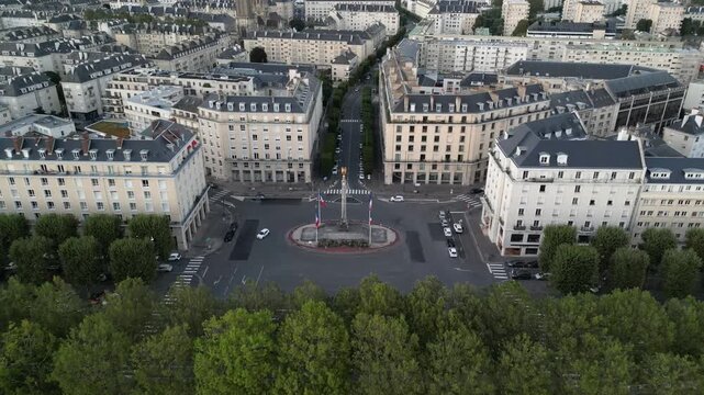 Aerial view of Place Foch showing muted tones of buildings and the roundabout with trees, Caen, Normandy, France.