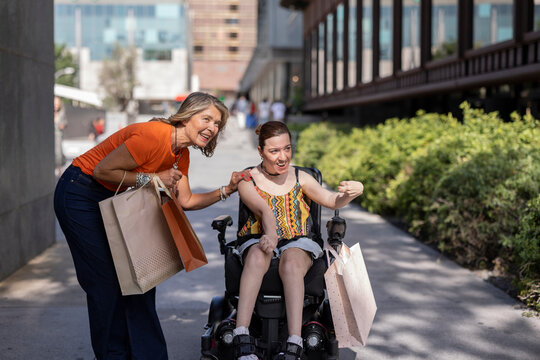 Happy woman with disability enjoying shopping with friend