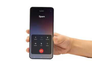 A hand holds a smartphone displaying an incoming call identified as Spam on a