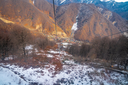 view of the valley below with a bit of snow and orange mountains
