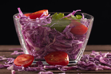 Glass bowl filled with red cabbage and sliced tomatoes