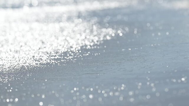 Sparkling wet sand with ocean reflection bokeh