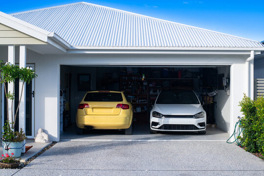 two cars parked in garage, one yellow and one white