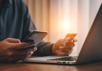 Man using smartphone and credit card with laptop for online payment