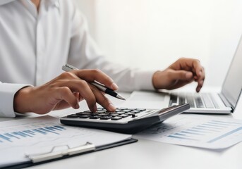 Person using calculator and laptop with financial reports