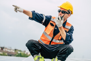 Worker coordinates solar panel installation on a rooftop during daytime