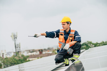 Worker installs solar panels on a rooftop in a city under a cloudy sky while using a tool for adjustments