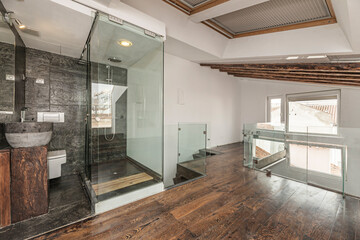 Modern bathroom ambiance with a round porcelain sink, matte black faucets, and a walk-in shower enclosure