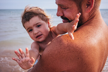 Dad Holding His Little Daughter on the Beach.