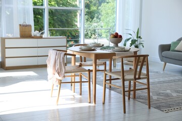 Stylish table setting, chairs and decor in dining room. Interior design