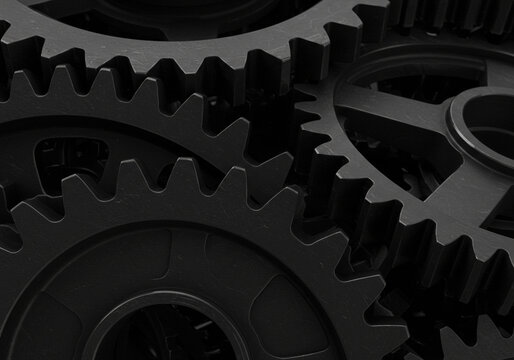A close up black and white image showing multiple interlocking gears and their intricate teeth