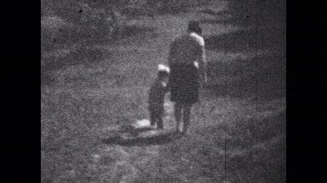 Old film, Mother child walking away by nature park path in summer, back view. Happy parent, daughter walk. Maternal support, care. Black white nostalgic family. Vintage archive. Archival retro 1960s