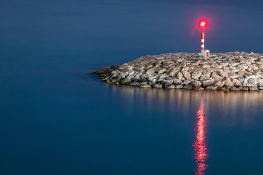 Tranquil lighthouse at dusk with sea reflection