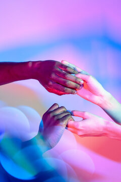 Multiethnic hands in vibrant lighting