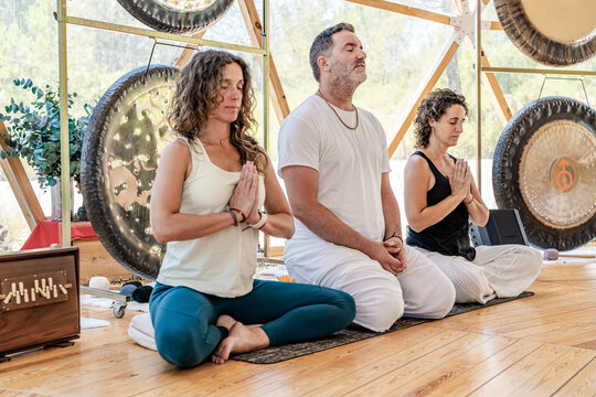 Sound therapists in meditation during a gong bath session