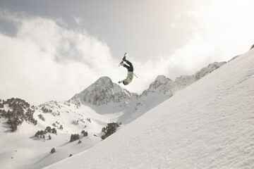 Snowboarder performing a daring freeride trick in mountains