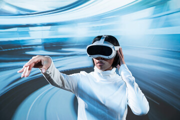 Latin woman using VR headset with hand outstretched