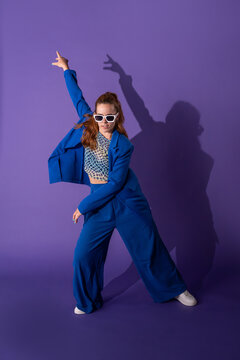 Young woman dancer posing with purple backdrop