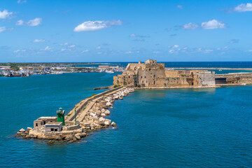 Aerial View of Venetian Fortress in the Sea, Alfonsino castle and lighthouse at the entrance to the port seen from a ferry boat while leaving, Brindisi, Puglia, Italy