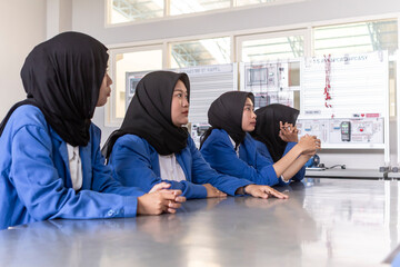Asian Muslim students in modern classroom technology lesson