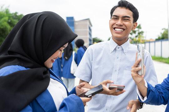 Asian students sharing a joyful moment on campus - Powered by Adobe