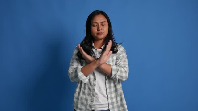 Displeased young asian woman isolated on blue background in studio. People lifestyle concept. Pointing fingers on herself ask say who me no thanks i do not need it