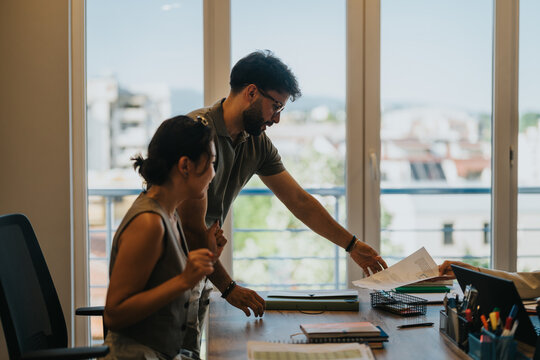 A young couple consults with a financial advisor in a modern bank office. They are reviewing documents and discussing plans related to loans, showcasing a professional and collaborative atmosphere. - Powered by Adobe