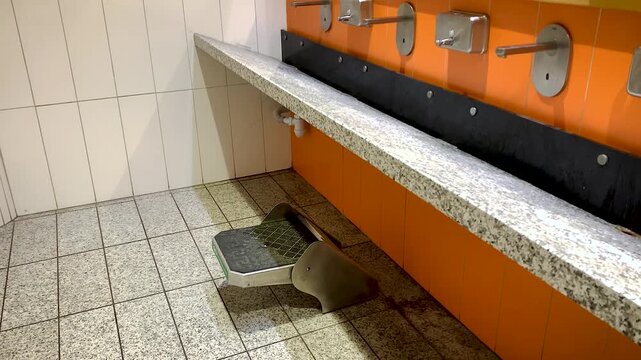 Washbasin podium for children in a public toilet .Children's shopping centre adapted for short stature