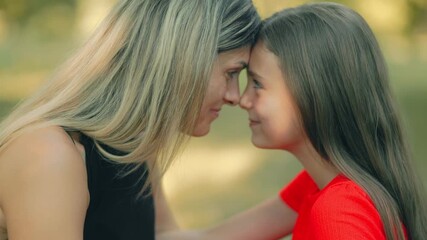 Loving mother and daughter touch noses in a sweet outdoor bonding moment - Powered by Adobe