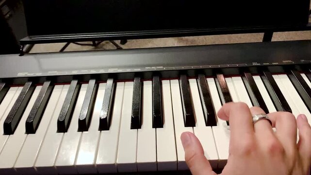 Hand playing piano practice.First-person view fingering the keys