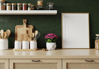 Stylish kitchen countertop featuring wooden utensils, a potted plant, and a blank picture frame against a dark green wall. 
