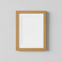 A simple wooden photo frame with a white mat, empty and hanging against a light gray wall.
